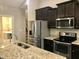 Kitchen featuring stainless steel appliances, granite counters, and dark cabinets at 191 W Cultivator Way, Clayton, NC 27520