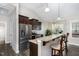 Kitchen with stainless steel appliances, dark brown cabinets, and a breakfast bar with seating at 191 W Cultivator Way, Clayton, NC 27520