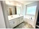 This bathroom features a double vanity, soaking tub, a window, and tile flooring at 193 Falls Of The Cape Dr, Lillington, NC 27546