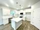 Bright kitchen featuring white cabinetry, island with seating, stainless appliances, and hard surface floors at 193 Falls Of The Cape Dr, Lillington, NC 27546