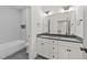 Modern bathroom with double vanity, tub with tile surround, and sleek fixtures, combining style and functionality at 20 Serenity Woods Trl, Franklinton, NC 27525