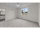 Bedroom with gray carpet features a ceiling fan, and natural light with a partial view of the bathroom at 20 Serenity Woods Trl, Franklinton, NC 27525
