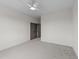 Neutral-toned bedroom with gray carpet and ceiling fan features a doorway leading to a walk-in closet for ample storage at 20 Serenity Woods Trl, Franklinton, NC 27525