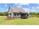 Exterior angle featuring the back porch, a lush lawn, and stylish gray siding at 20 Serenity Woods Trl, Franklinton, NC 27525