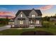 Stunning two-story home with gray siding, black trim, and a well-manicured lawn at sunset at 20 Serenity Woods Trl, Franklinton, NC 27525