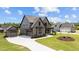 Attractive two-story home with gray siding, black trim, an attached garage, and well-kept landscaping at 20 Serenity Woods Trl, Franklinton, NC 27525