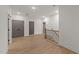 Bright hallway with hardwood floors, grey doors, and a staircase with wooden handrail and black iron spindles at 20 Serenity Woods Trl, Franklinton, NC 27525