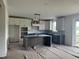 Open kitchen featuring white cabinets, a large island, and sliding glass doors to backyard at 20 Serenity Woods Trl, Franklinton, NC 27525
