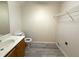 Bathroom with a toilet, sink and vanity with wood cabinets and tiled floor; adjacent laundry closet at 202 Allen St # A/B, Creedmoor, NC 27522