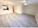 Open-concept living room with light-toned flooring, a ceiling fan, and views into the kitchen at 202 Allen St # A/B, Creedmoor, NC 27522