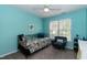 Bright bedroom with turquoise walls, a daybed, accent chair, and ceiling fan at 206 Newberry Ln, Durham, NC 27703