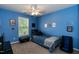 Bedroom with blue walls, carpet, ceiling fan, and window for natural light at 206 Newberry Ln, Durham, NC 27703