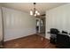 Formal dining room featuring hardwood floors, elegant lighting, and a view into the kitchen at 206 Newberry Ln, Durham, NC 27703