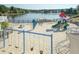 Community playground with slides, swings and climbing structures, with lake and trees in the background at 206 Newberry Ln, Durham, NC 27703