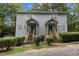 Charming duplex featuring wood siding, shuttered windows, and matching entrances, with green bushes and trees at 207 Mill St # A/B, Creedmoor, NC 27522