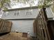 View of a blue two-story house with light blue siding, white windows, and a brown fence at 207 Mill St # A/B, Creedmoor, NC 27522