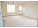 Bright living room features neutral carpet, a ceiling fan, and a door leading to outdoor space at 207 Mill St # A/B, Creedmoor, NC 27522