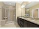 Bright bathroom featuring a glass shower, double vanity with granite countertop and large mirror at 207 Wildfell Trl, Cary, NC 27513