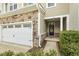Inviting front entrance featuring a stone facade, a well-maintained lawn, and a black front door at 207 Wildfell Trl, Cary, NC 27513