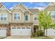 Charming townhome with a two-car garage, stone accents, and neutral siding, offering curb appeal at 207 Wildfell Trl, Cary, NC 27513