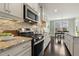 Bright kitchen boasts stainless appliances, tile backsplash, granite counters and eat-in dining area at 207 Wildfell Trl, Cary, NC 27513