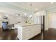 Open concept kitchen features island with granite counters, stainless fridge, and view to the living area at 207 Wildfell Trl, Cary, NC 27513