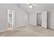 Spacious bedroom with neutral walls and carpet plus ceiling fan and multiple closets at 2100 Thornblade Dr, Raleigh, NC 27604