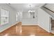Open dining area with hardwood floors, a view of the kitchen, adjacent to stairs and entryway at 2100 Thornblade Dr, Raleigh, NC 27604