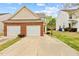 Charming exterior of home featuring a two-car garage, brick accents, and well-maintained landscaping at 2100 Thornblade Dr, Raleigh, NC 27604