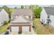 An aerial shot showing a two-story house with a brick-accented garage and neutral siding at 2100 Thornblade Dr, Raleigh, NC 27604