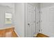 Bright hallway with pristine white doors, natural hardwood flooring, and a window that floods the space with natural light at 2100 Thornblade Dr, Raleigh, NC 27604
