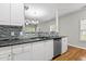 Inviting kitchen featuring stone countertops, stainless steel appliances, white cabinets, and an open design at 2100 Thornblade Dr, Raleigh, NC 27604