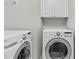 Convenient laundry area featuring modern, front-load washer and dryer with overhead cabinetry at 2100 Thornblade Dr, Raleigh, NC 27604