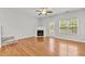 Cozy living room features fireplace, access to backyard and stairs, and ceiling fan at 2100 Thornblade Dr, Raleigh, NC 27604