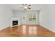 Bright living room featuring hardwood floors, fireplace, a ceiling fan, and access to backyard at 2100 Thornblade Dr, Raleigh, NC 27604