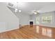 Bright living room featuring hardwood floors, a fireplace, a ceiling fan, and a door to the outside at 2100 Thornblade Dr, Raleigh, NC 27604