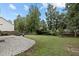 A spacious backyard offers an outdoor living space with a stone fire pit and plenty of space for entertaining at 2112 Queensway Ct, Creedmoor, NC 27522