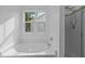 Bright bathroom featuring a soaking tub with window and a glass-enclosed shower at 2112 Queensway Ct, Creedmoor, NC 27522