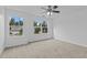 A bright bedroom with plush carpeting and views through two large windows at 2112 Queensway Ct, Creedmoor, NC 27522