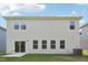 View of the back of a light siding home with a sliding glass door and windows at 2207 Cherry Creek Rd, Haw River, NC 27258