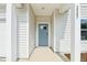 Close-up of the entryway with a light blue front door and white siding, pillars, and trim at 2207 Cherry Creek Rd, Haw River, NC 27258