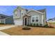 Charming two-story home with gray siding, stone accents, and a well-manicured lawn at 235 Mallard Loop Dr, Clayton, NC 27527