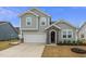 Charming two-story home with gray siding, stone accents, and a two-car garage at 235 Mallard Loop Dr, Clayton, NC 27527