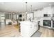 Open-concept kitchen featuring an island, white cabinets, and stainless steel appliances at 235 Mallard Loop Dr, Clayton, NC 27527