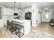 Modern kitchen with white cabinets, a large island, and seating for three at 235 Mallard Loop Dr, Clayton, NC 27527