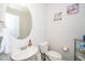 Well-lit powder room with pedestal sink, toilet, and decorative wall art at 235 Mallard Loop Dr, Clayton, NC 27527