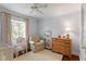 Charming bedroom with a crib, vanity, and cozy armchair, bathed in natural light at 2714 Gordon St, Raleigh, NC 27608