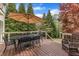 The back deck features an umbrella table set with black iron chairs with green foliage in the background at 317 Briarfield Dr, Apex, NC 27502