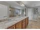 Well-lit bathroom with double sinks, granite countertop, large mirror, and tiled walk-in shower at 317 Briarfield Dr, Apex, NC 27502