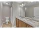 Bright bathroom featuring double granite vanity, a toilet, and neutral tile flooring at 317 Briarfield Dr, Apex, NC 27502